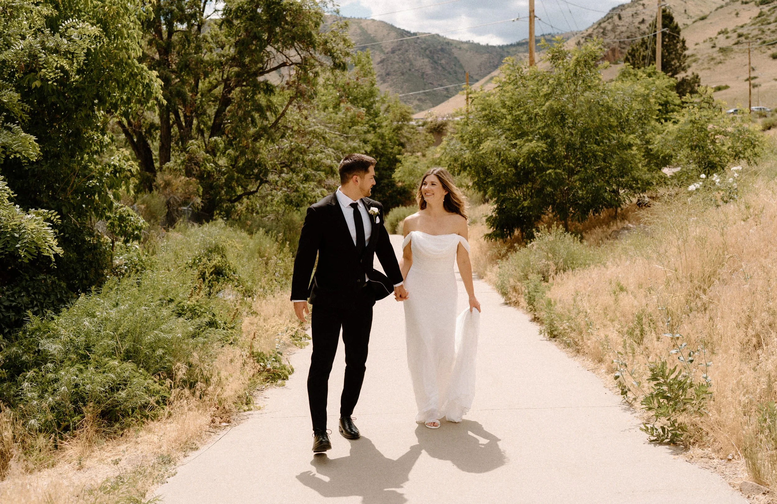Bride and groom walking on a path on wedding day at The Eddy in Golden Colorado