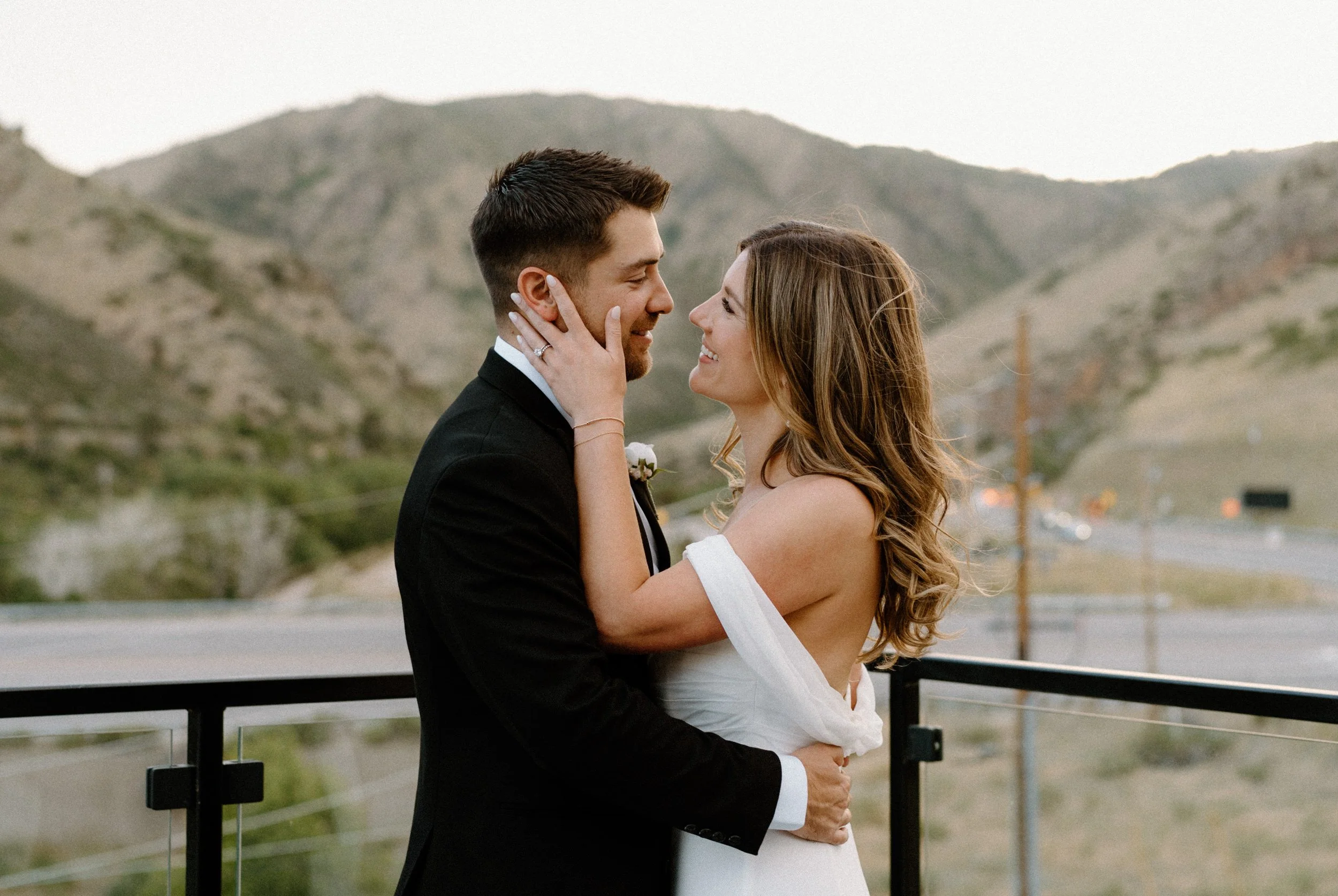 Bride and groom hugging each other on the balcony of The Eddy in Golden Colorado on wedding day