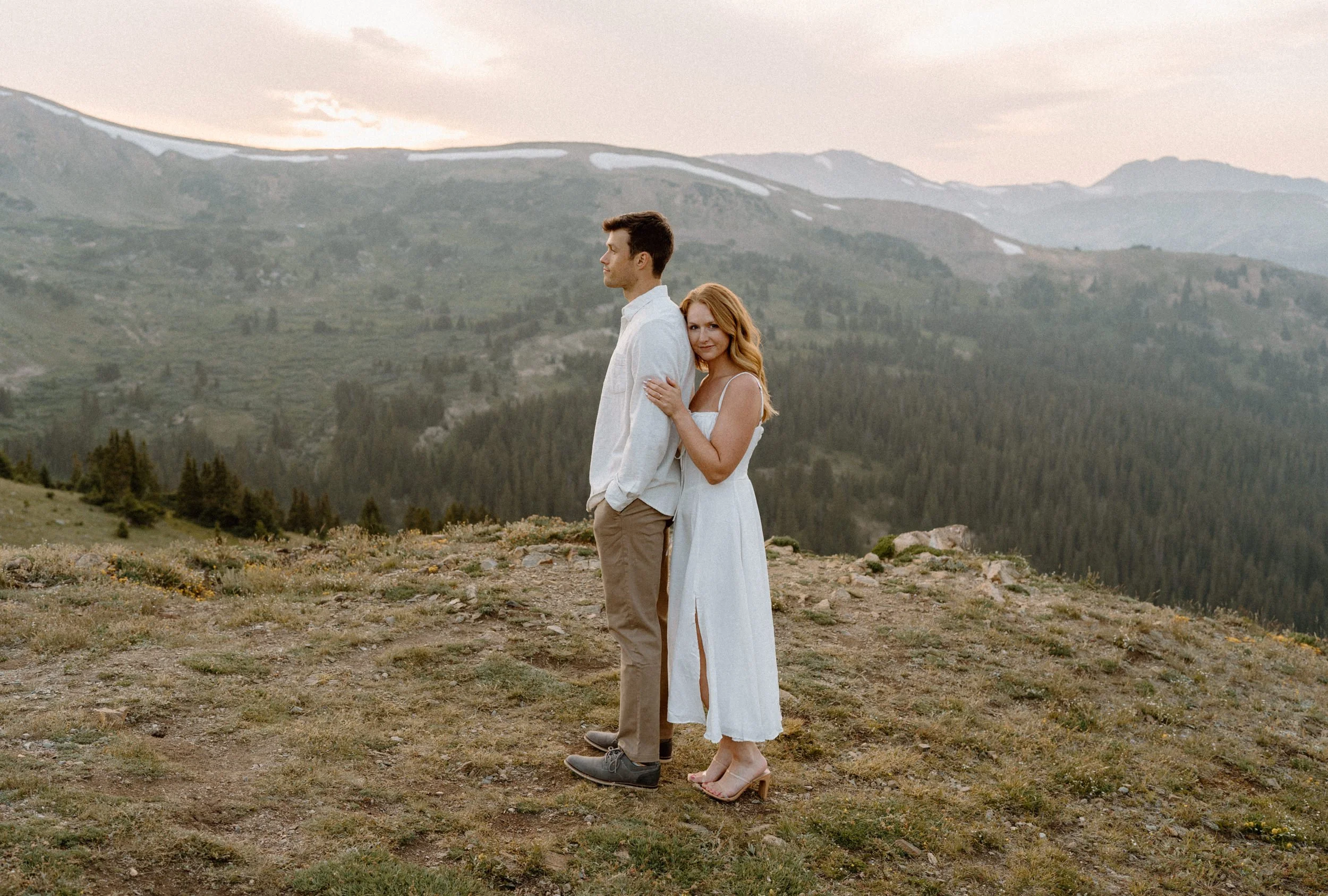Fiancée hugging fiancé from behind at Loveland Pass during engagement session