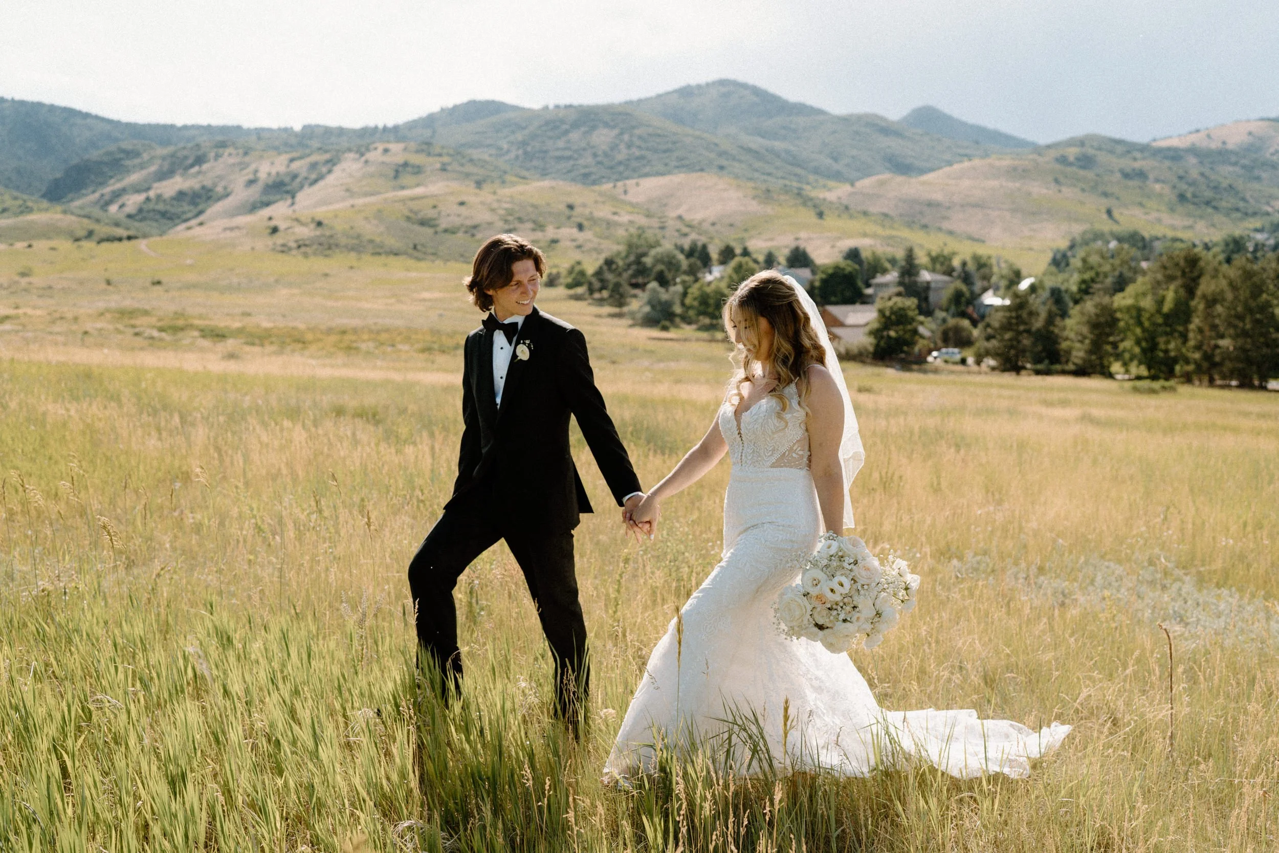 Bride and groom walking in a field on wedding day at The Manor House