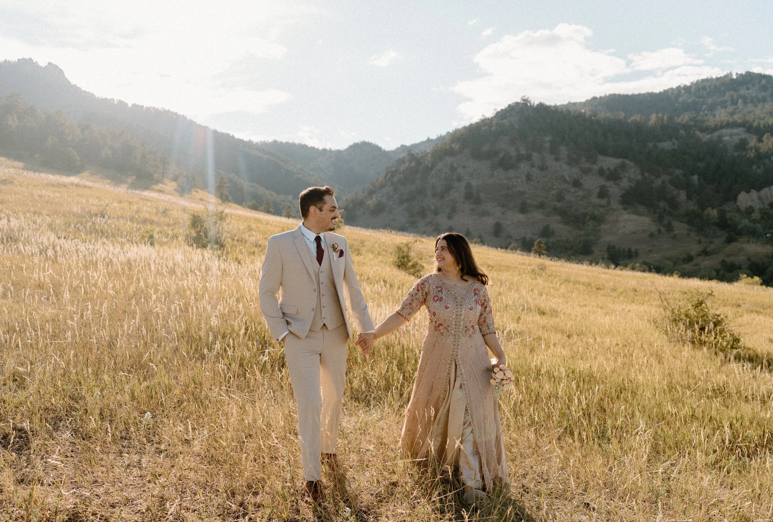 Couple holding hands and smiling at each other during an engagement session in Boulder Colorado