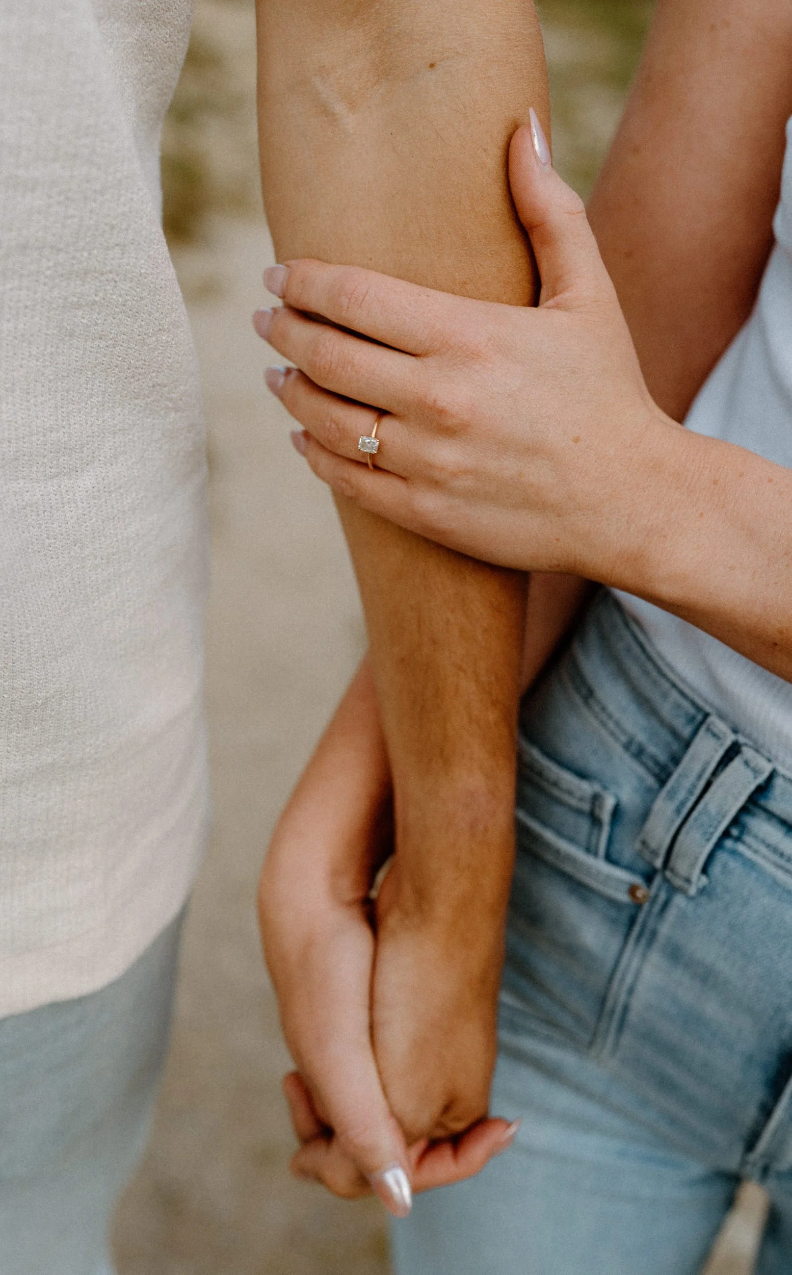 Couple holding hands showing engagement ring during an engagement session at Loveland Pass