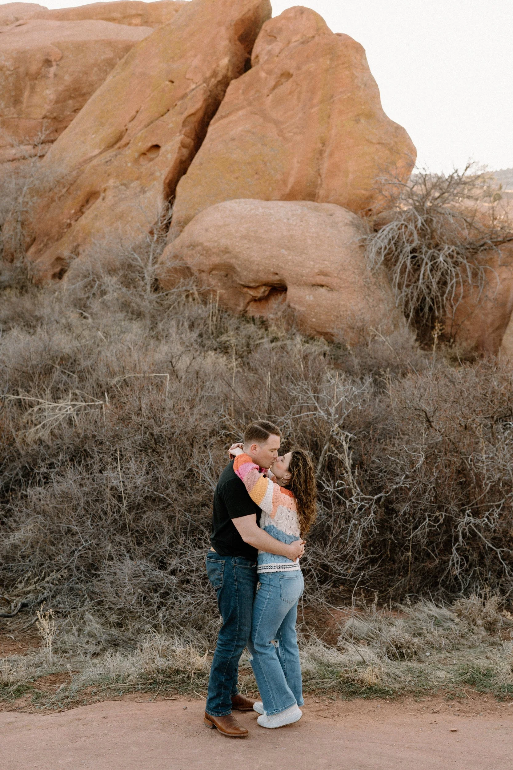 Couple kissing in Red Rocks during an engagement session
