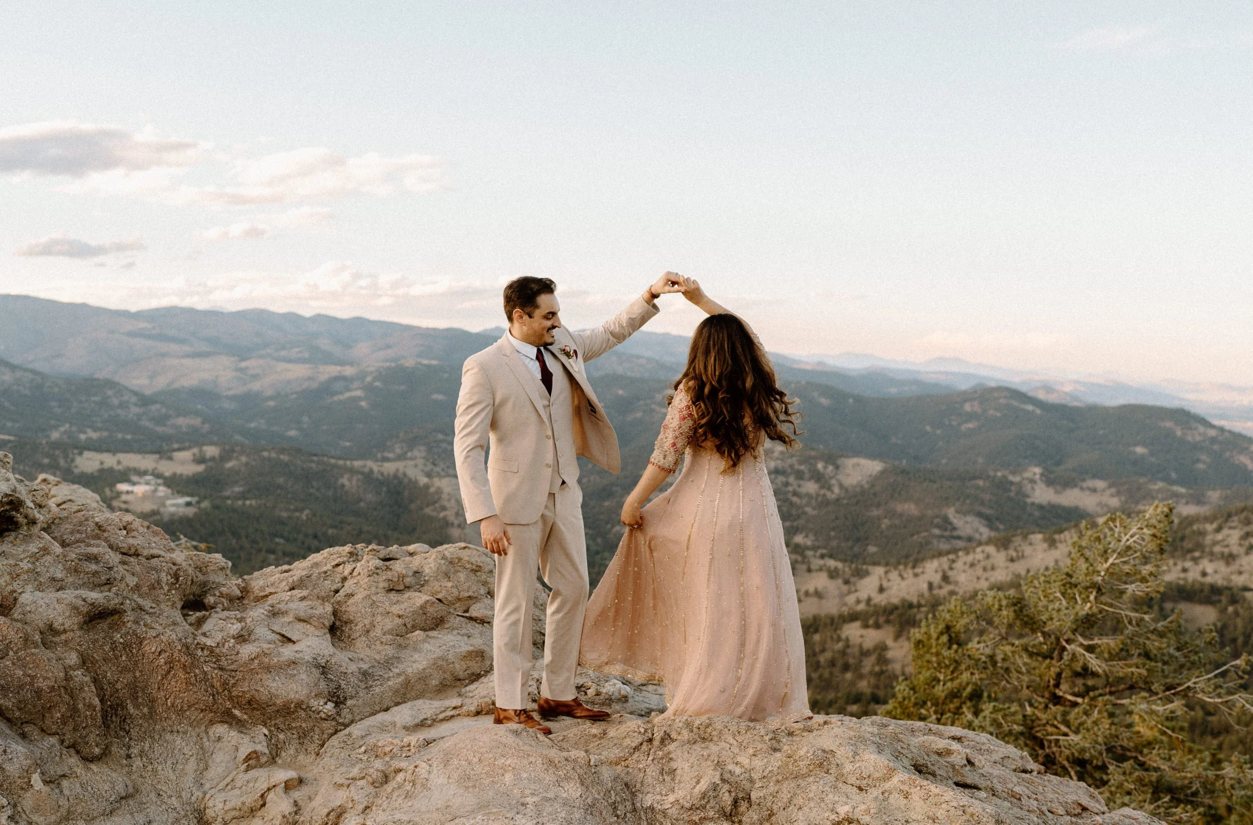 Fiancé twirling his fiancée on top of a mountain in Boulder Colorado during an engagement session
