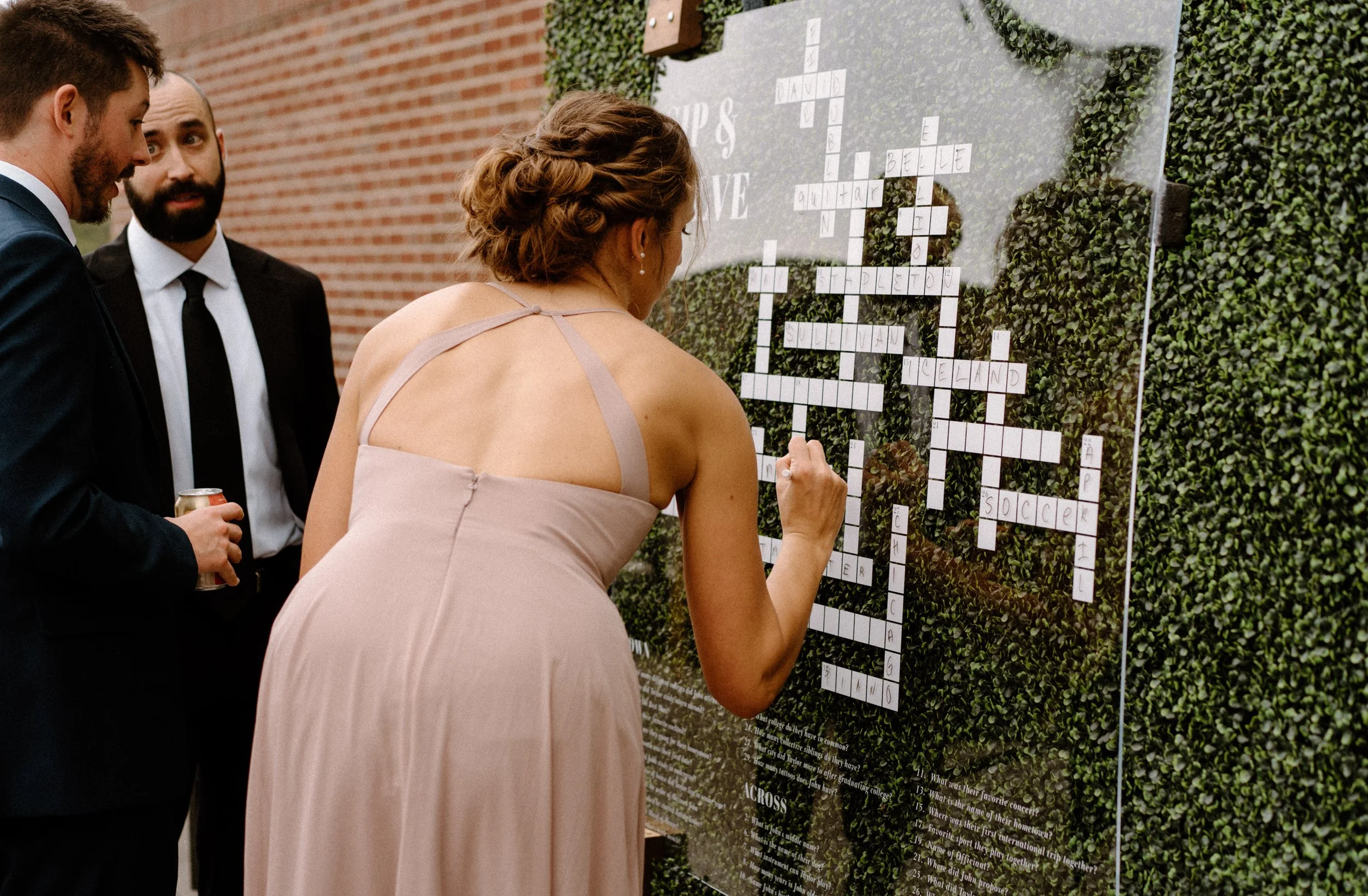 Wedding guest filling out a crossword puzzle at The Eddy in Golden Colorado