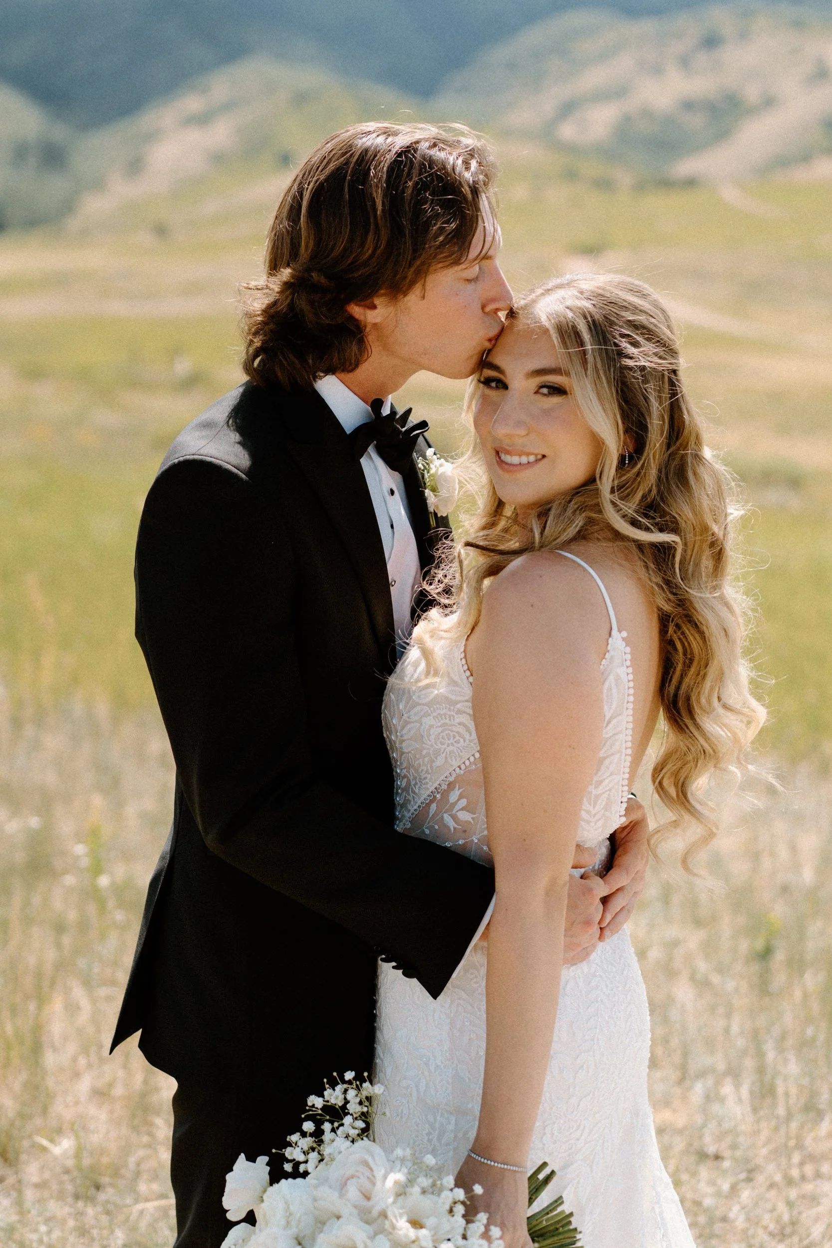 Groom kissing brides forehead during first look on wedding day at The Manor House