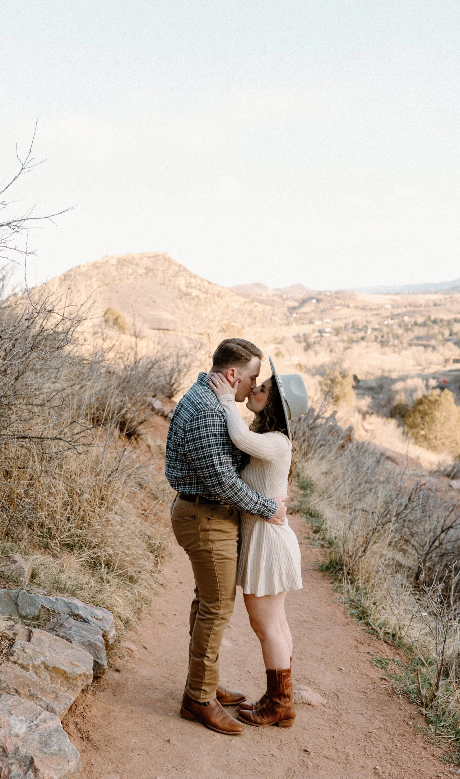 Couple kissing on a path at Red Rocks during engagement session