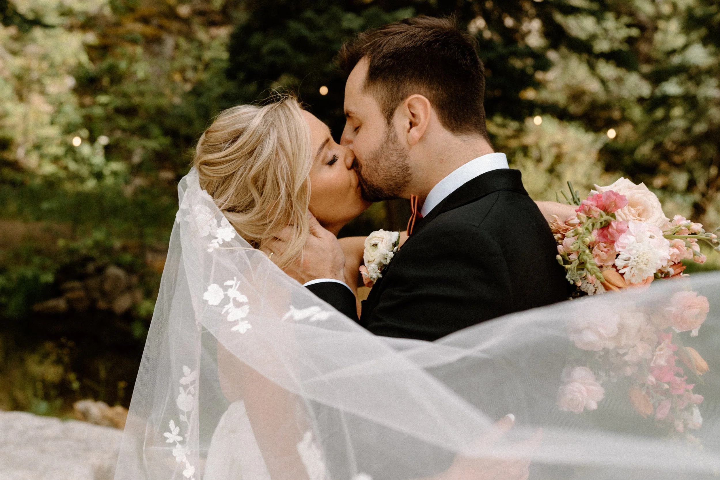 Bride and groom kissing through veil on wedding day at Blackstone Rivers Ranch