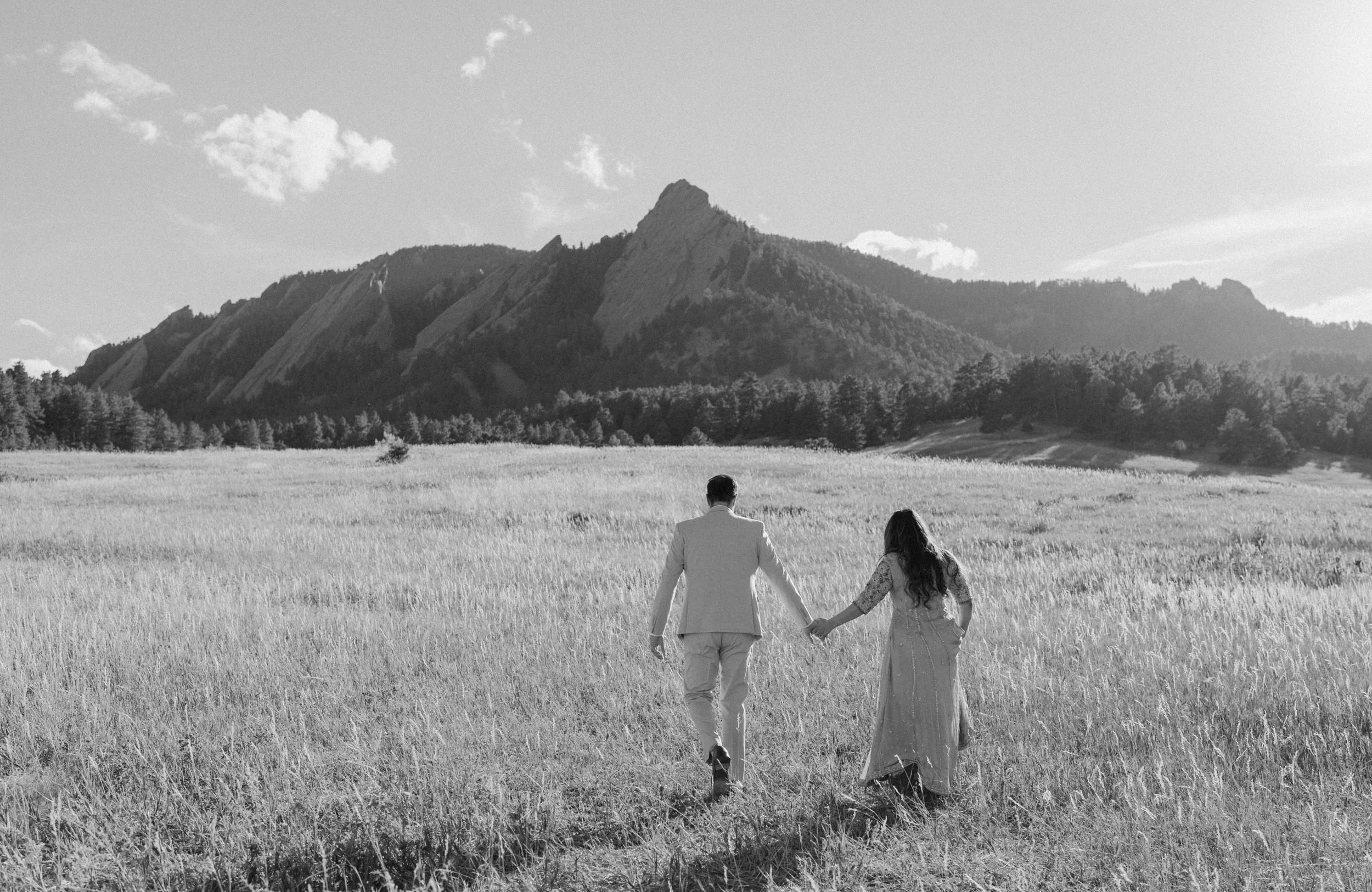 Couple hiking in a field in Boulder Colorado during an engagement session