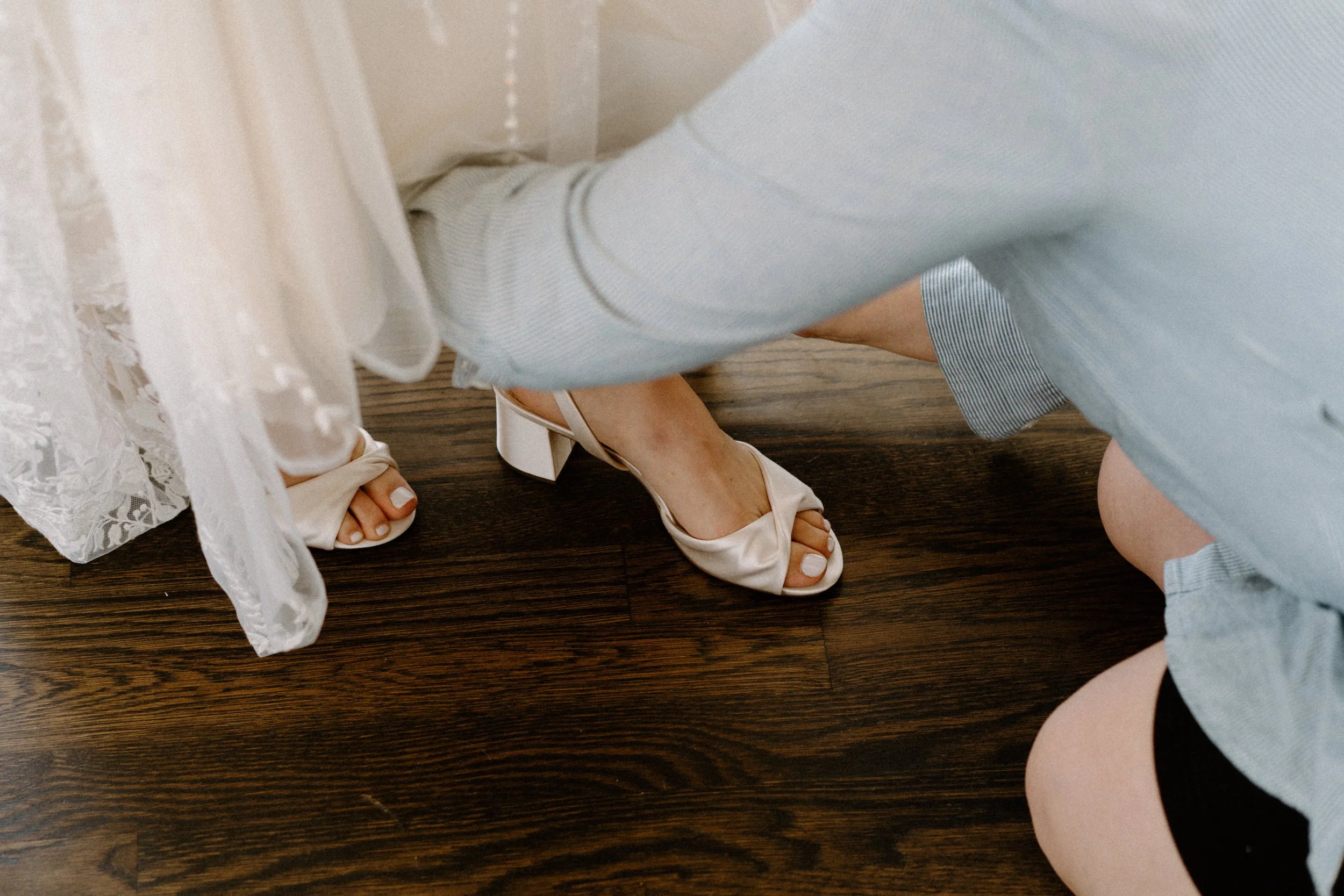 Bride putting on shoes on wedding day at The Manor House
