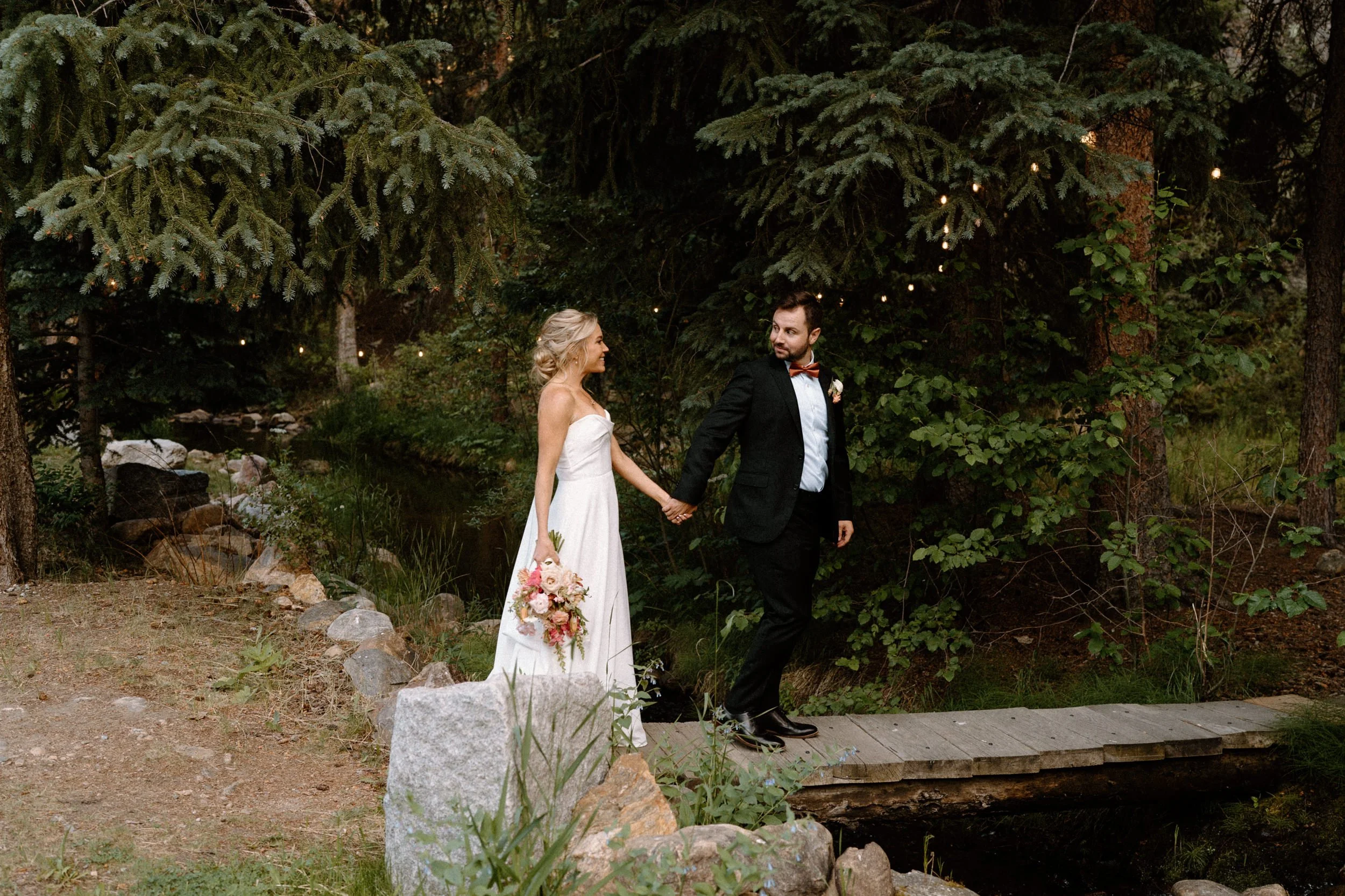 Bride and groom walking on a bridge at Blackstone Rivers Ranch