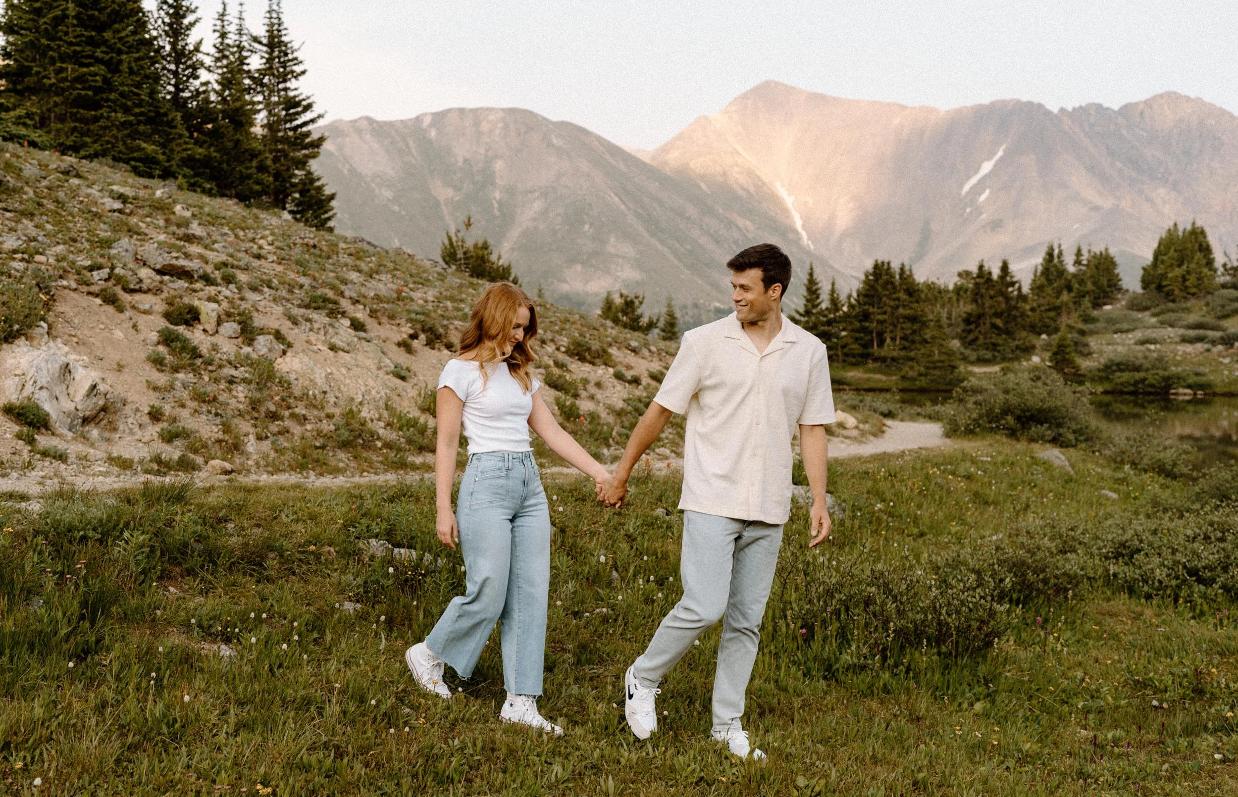 Couple hiking around Loveland Pass and holding hands during an engagement session