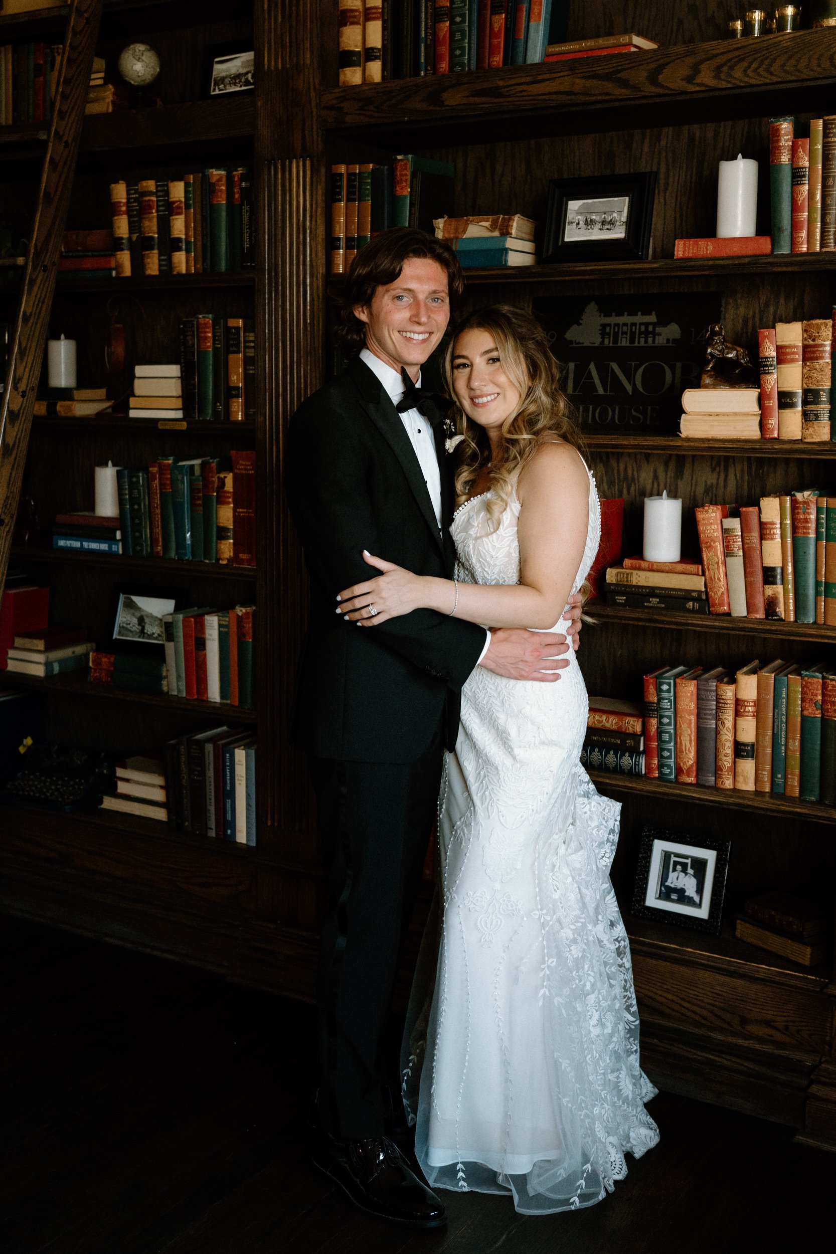 Bride and groom smiling in the library at The Manor House