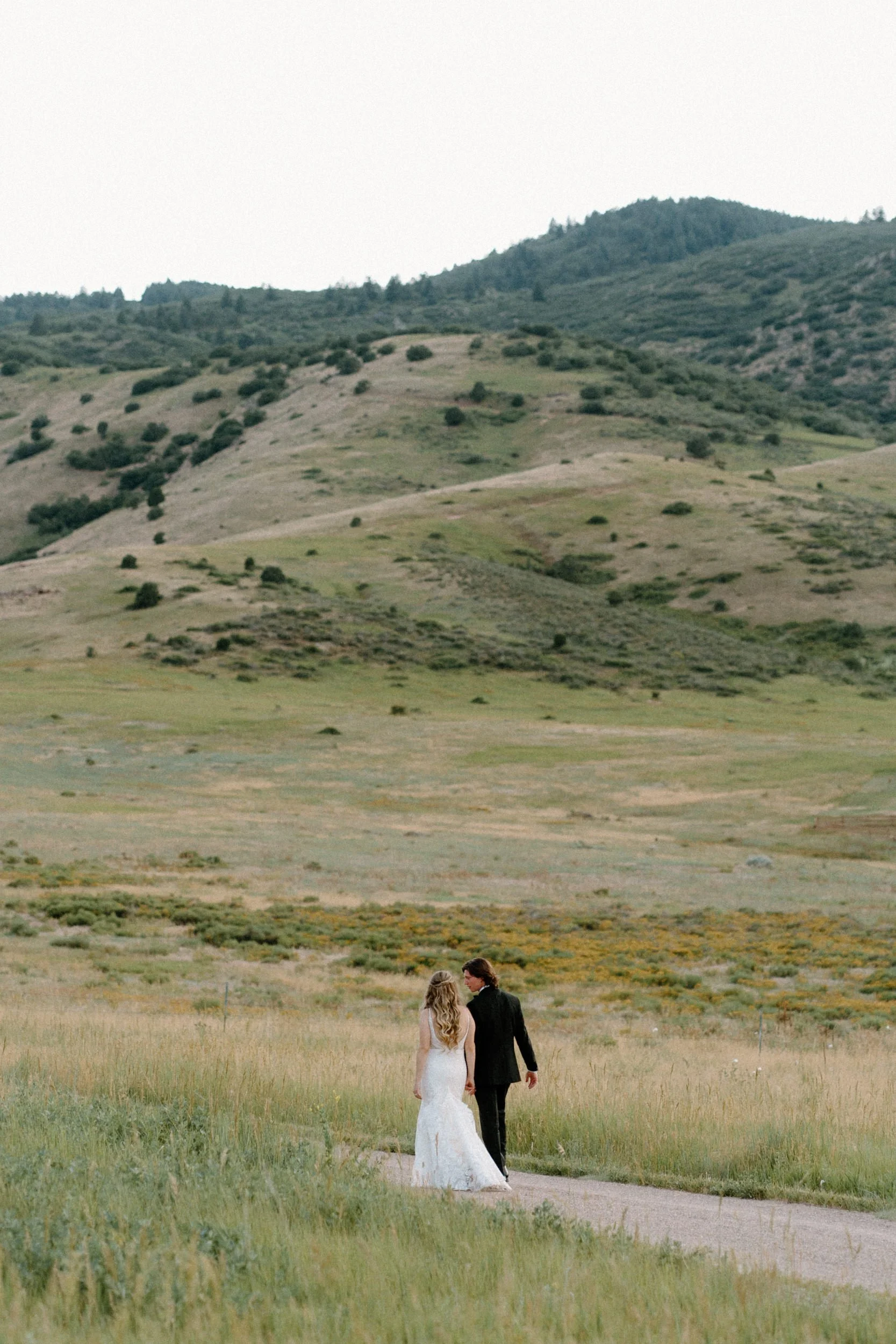 Bride and groom walking and holding hands on wedding day at The Manor House