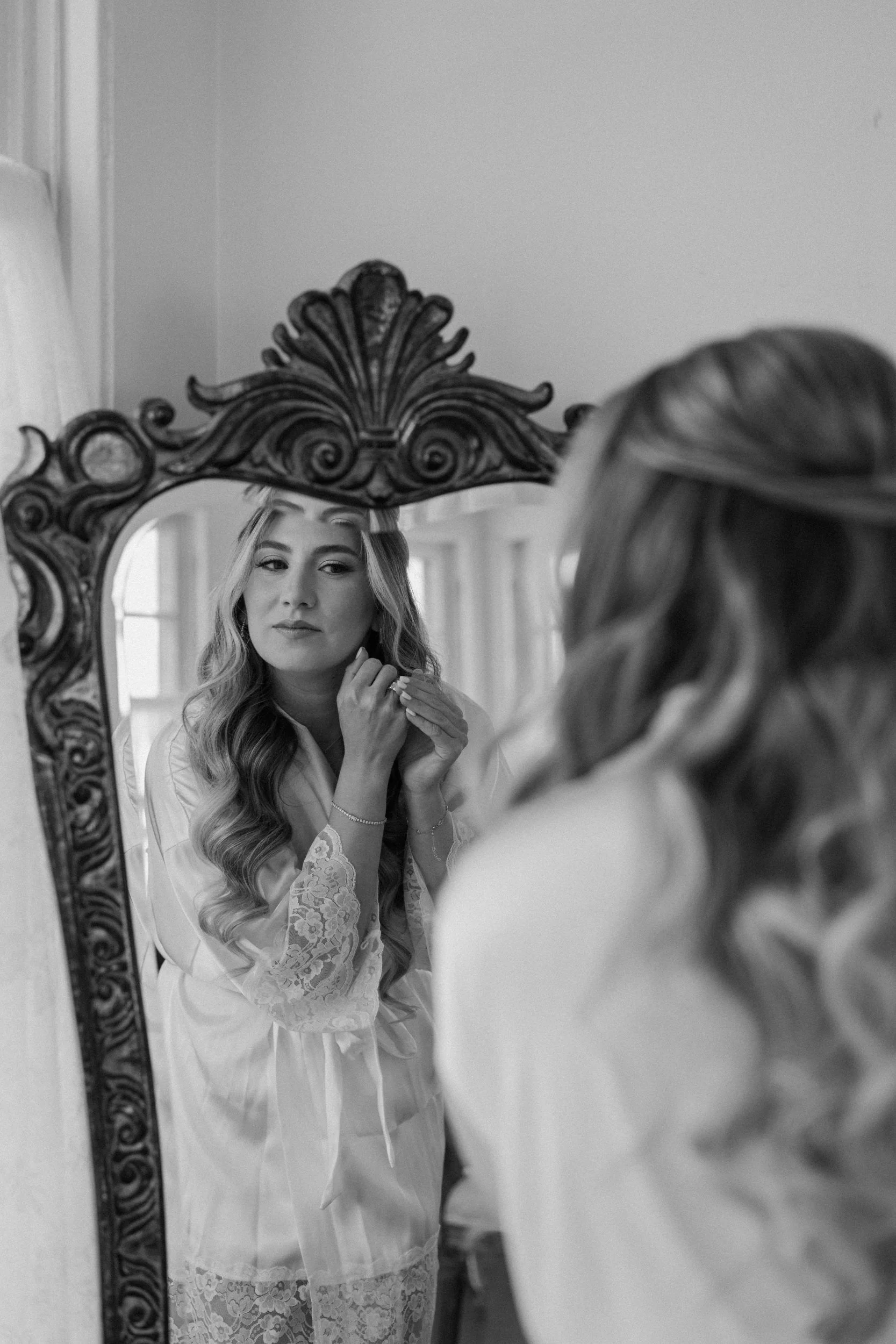 Bride putting earring in on wedding day at The Manor House