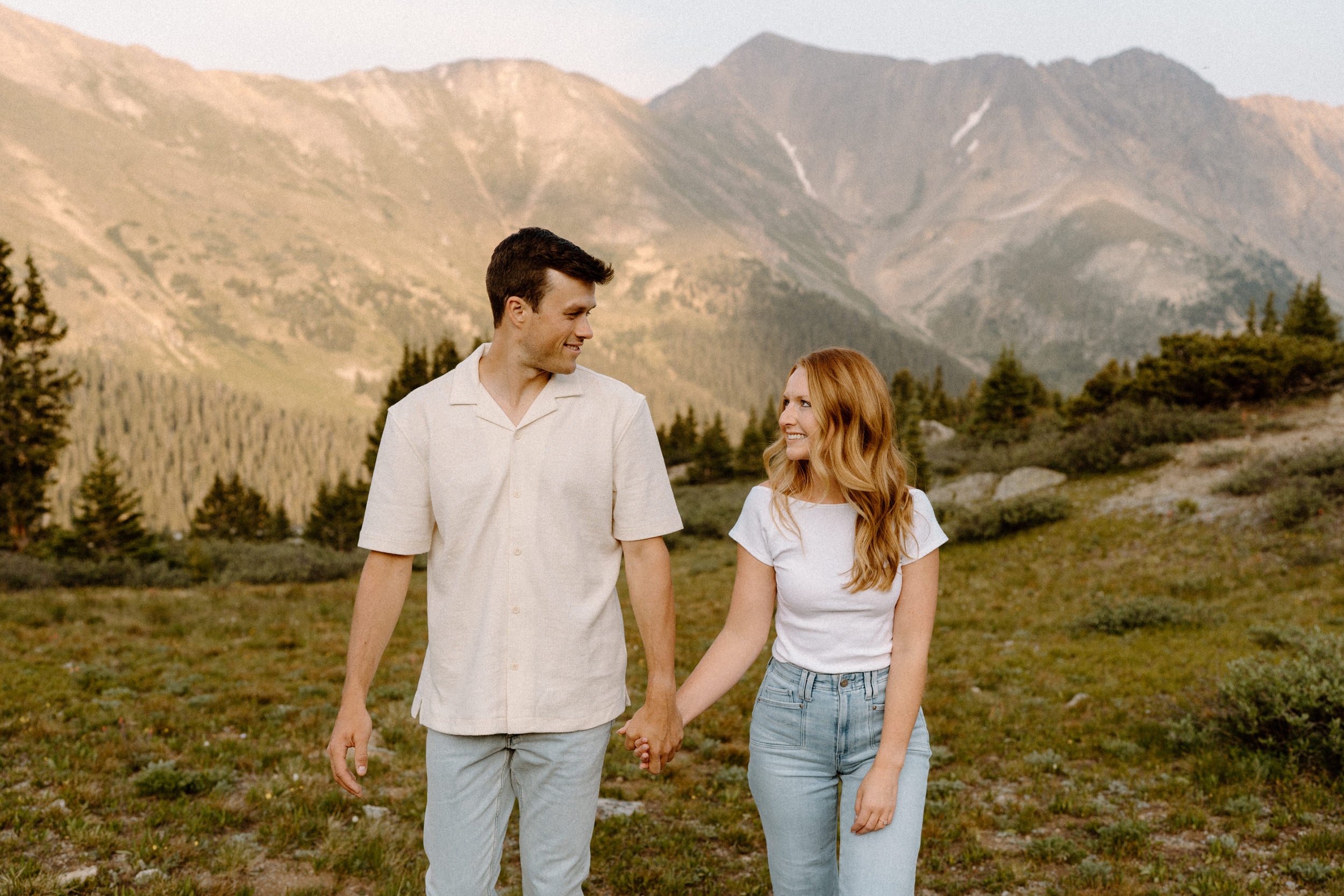Couple hiking and holding hands at Loveland Pass during engagement session