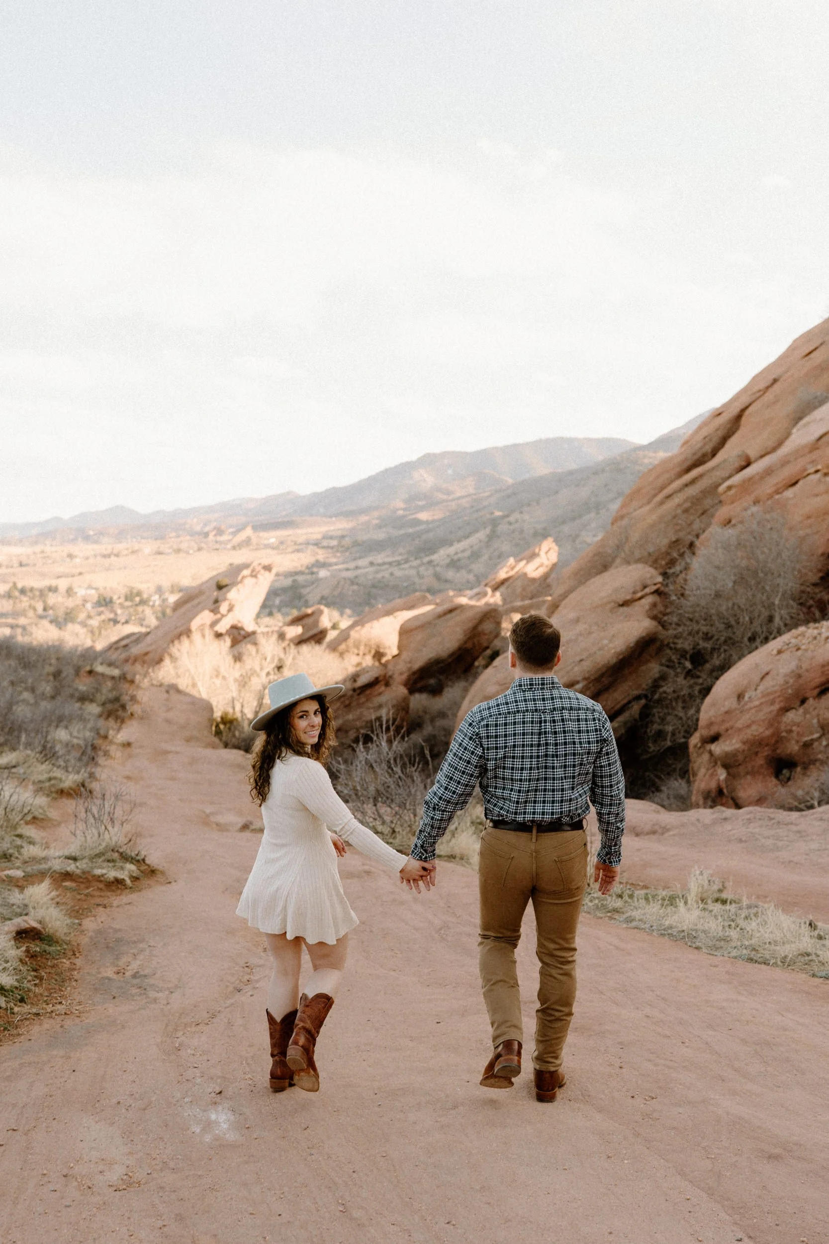 Couple walking during engagement session at Red Rocks