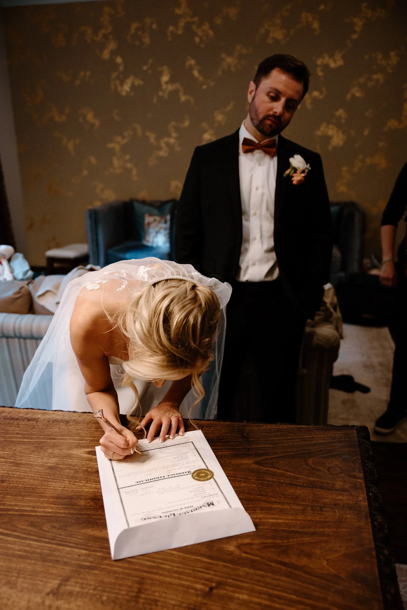 Bride signing marriage license on wedding day at Blackstone Rivers Ranch