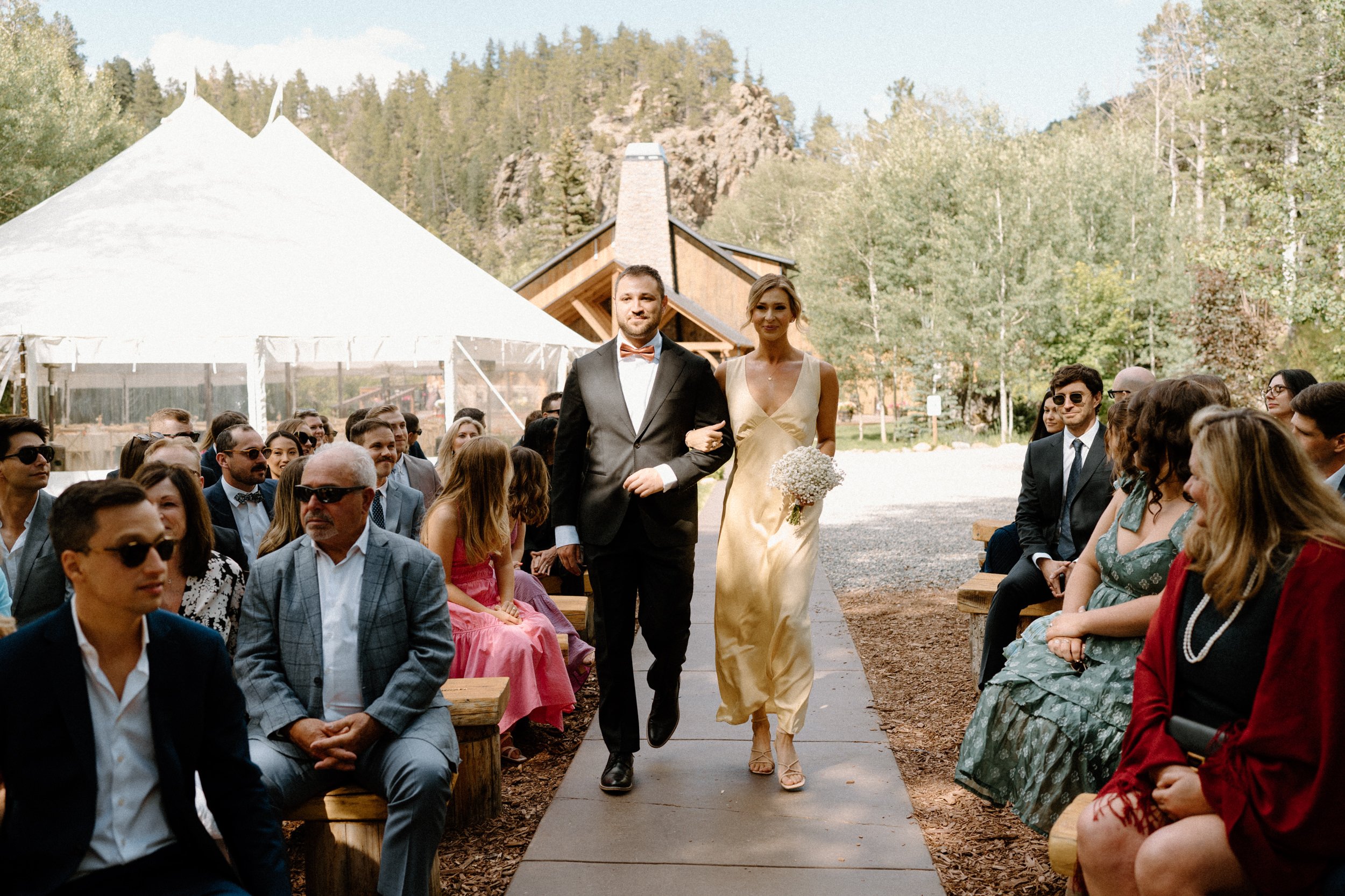 Bridesmaid and groomsmen walking down the aisle on wedding day at Blackstone Rivers Ranch