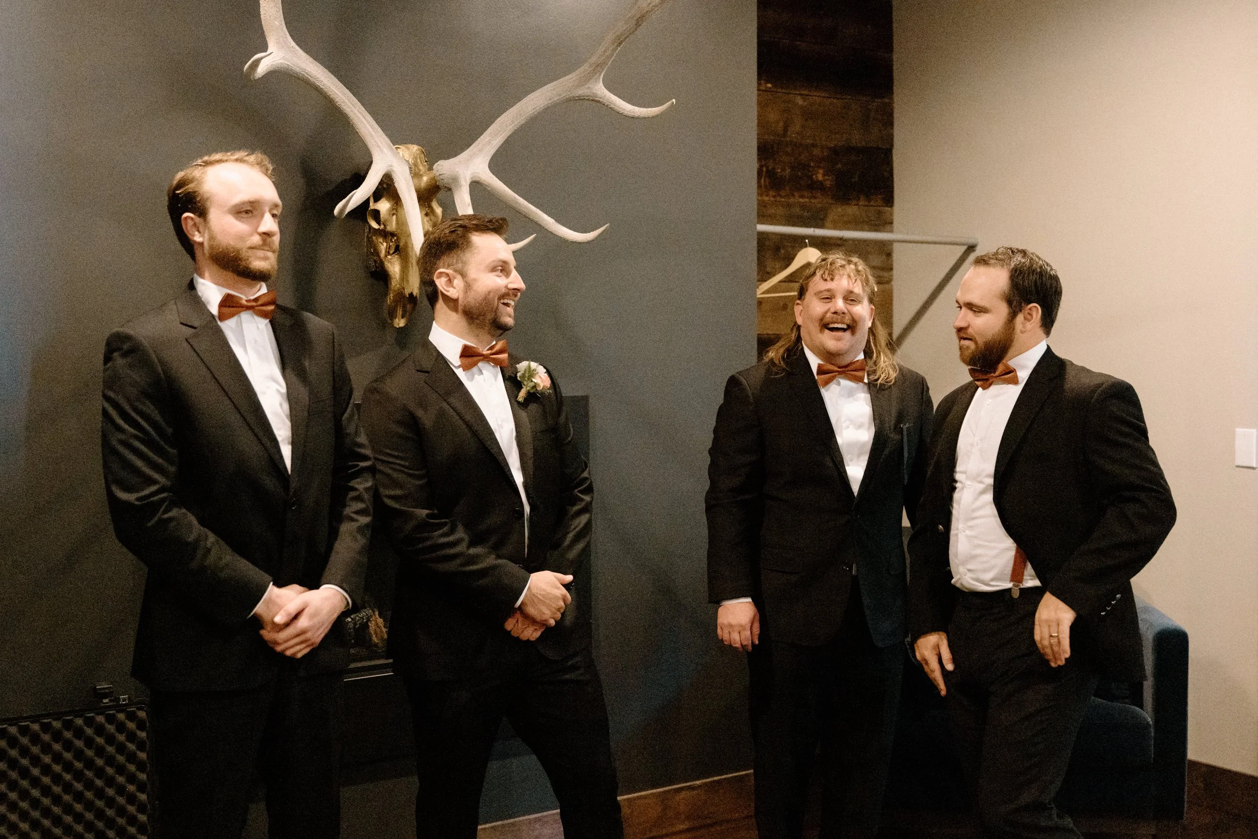 Groom and groomsmen laughing on wedding day at Blackstone Rivers Ranch