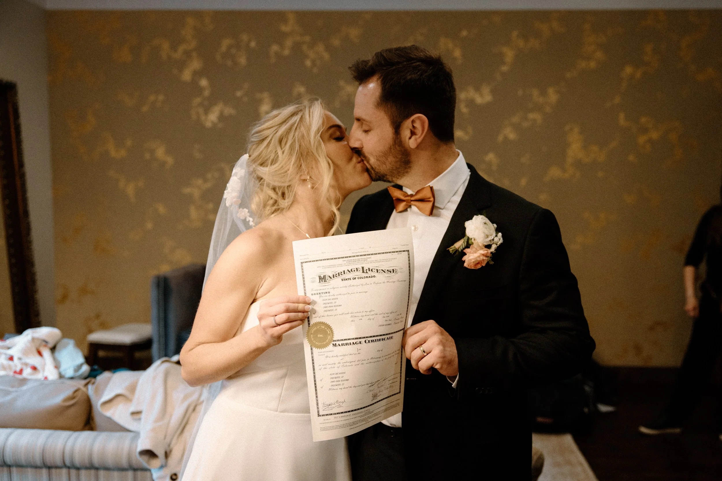 Bride and groom kissing with marriage license on wedding day at Blackstone Rivers Ranch