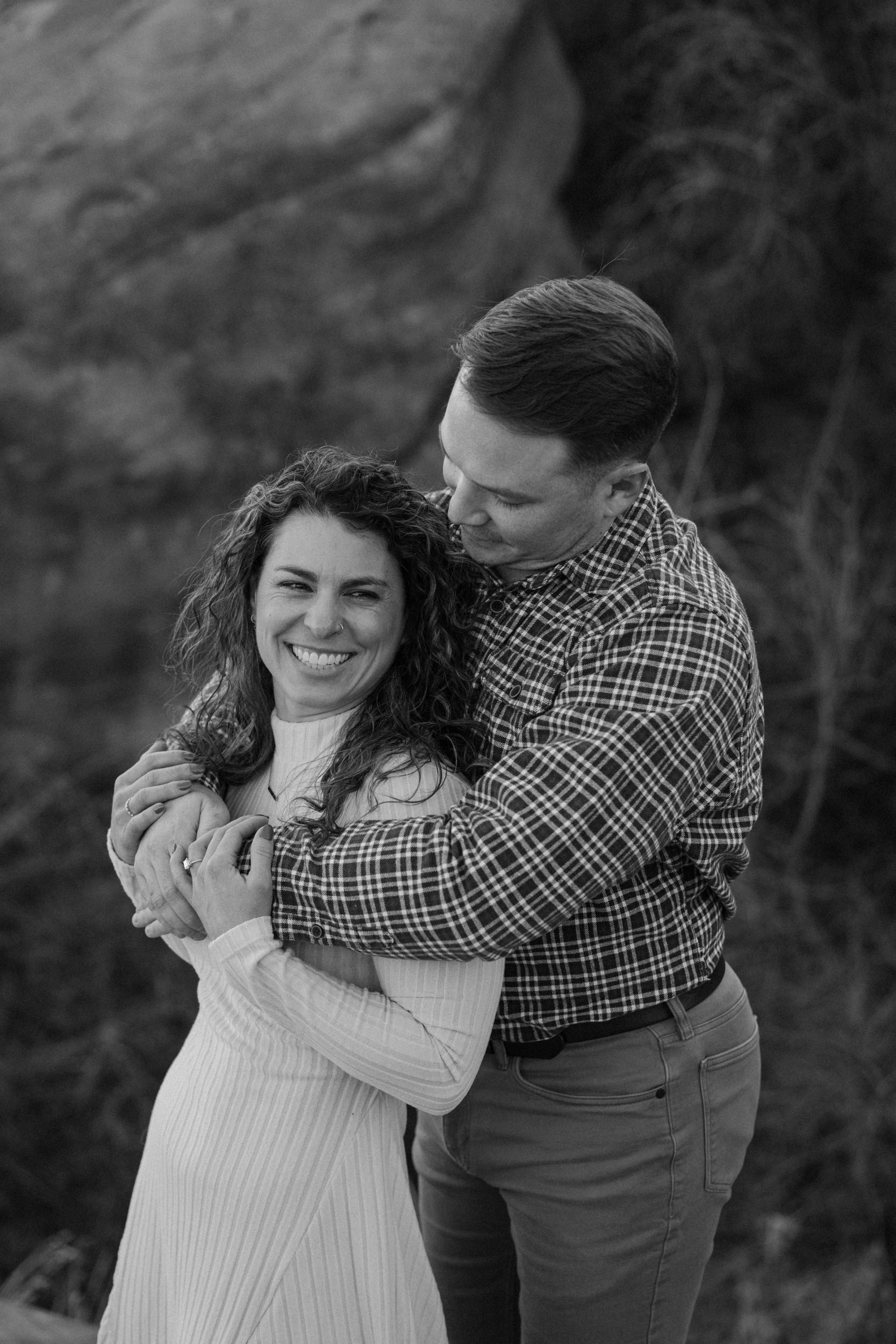 Couple hugging during engagement session at Red Rocks