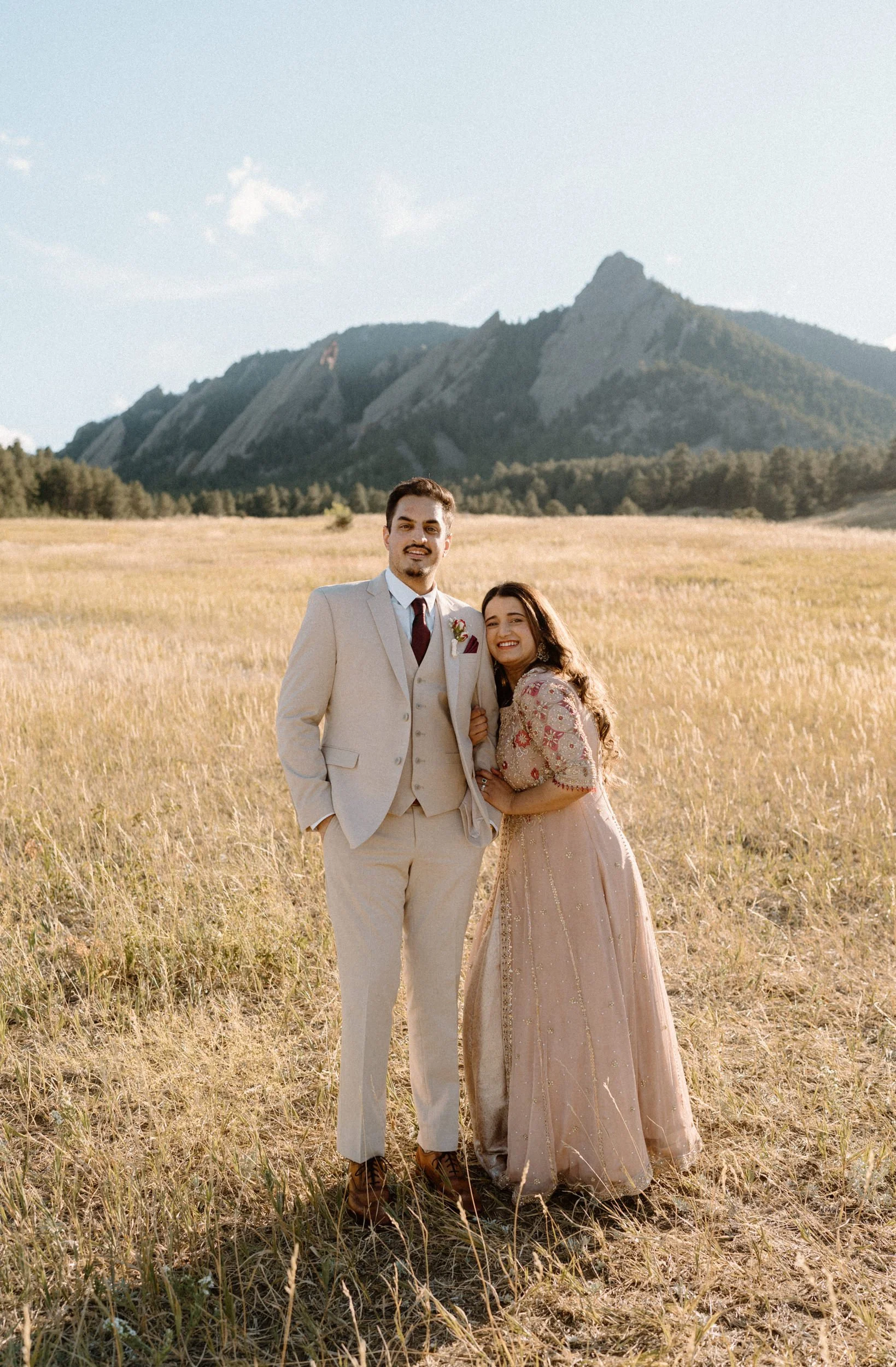 Couple smiling in front of the Flatirons during an engagement session in Boulder Colorado