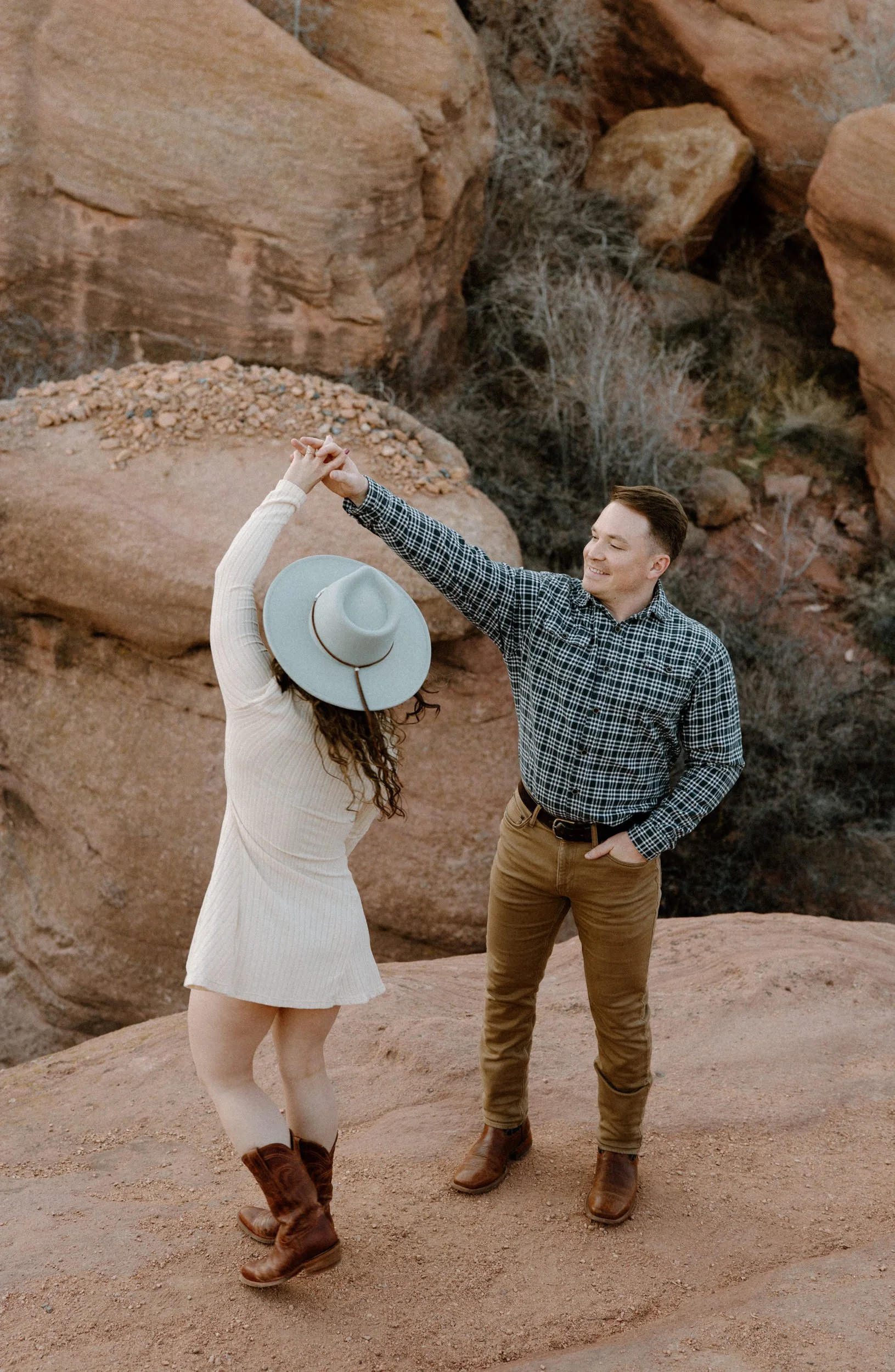 Fiancé twirling fiancée during engagement session in Red Rocks