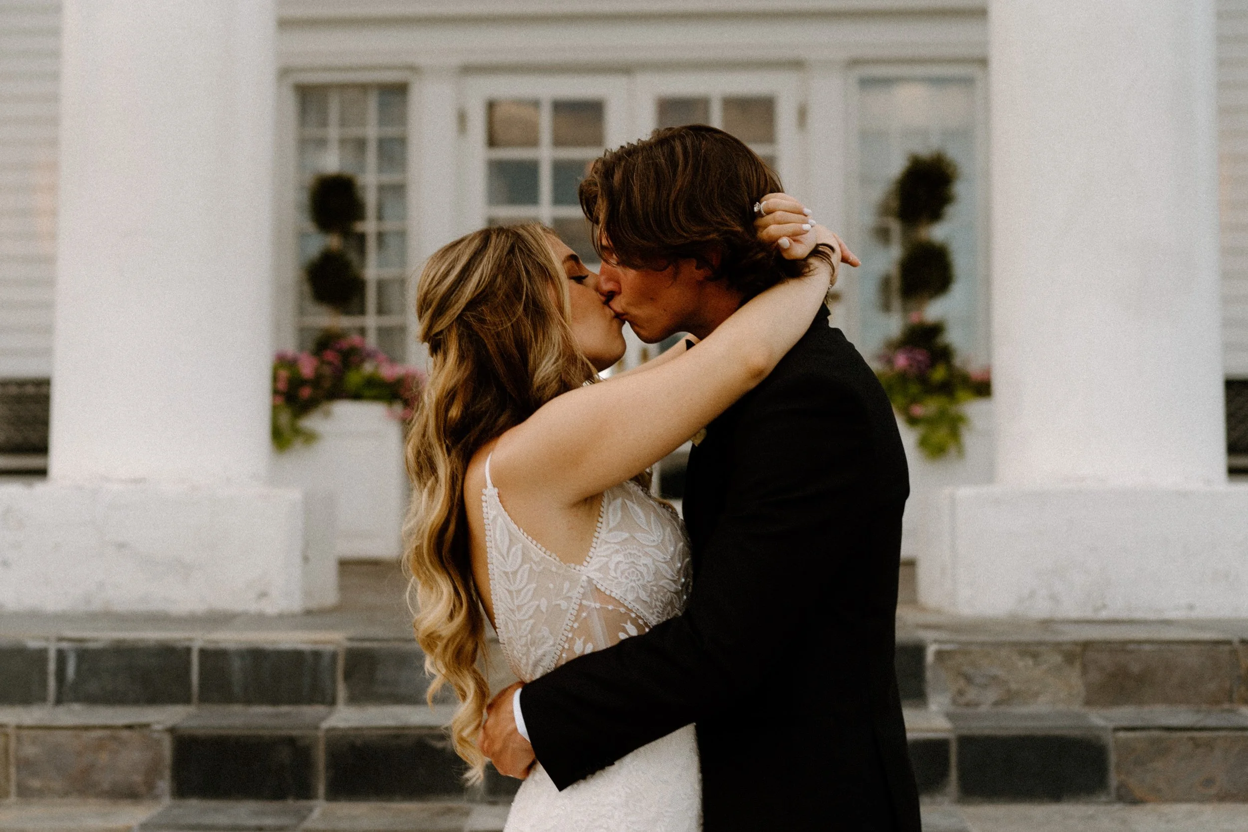 Bride and groom kissing outside The Manor House on wedding day