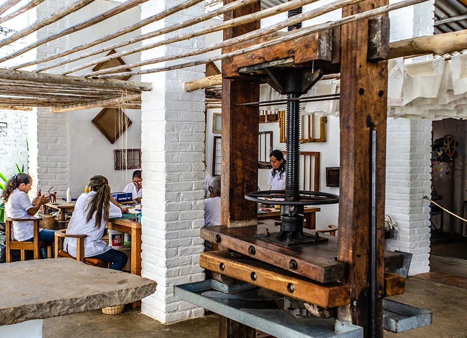 Women putting the final touches on hand-made paper products.