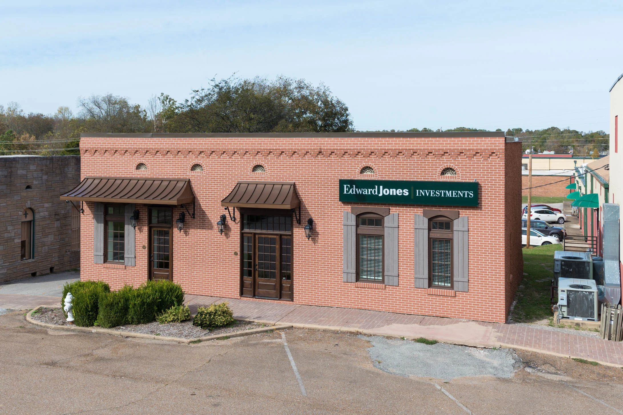 Newly constructed facade. Faux dry-vit brick, enlarged window openings, copper awnings, period style lighting, custom wood shutters, and the original brick work near the roof line were all part of the finished project. 