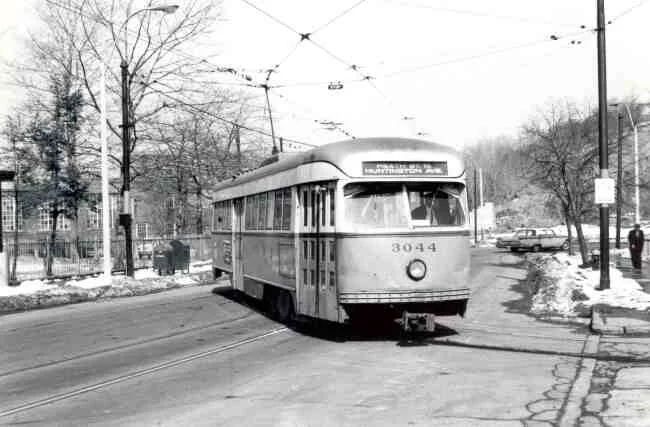 Trolley # 3044 is turning from South Huntington Avenue towards the Heath Street Loop in this 1967 photo. The Longwood Hospital's wrought iron fence can be seen to the left of the trolley.