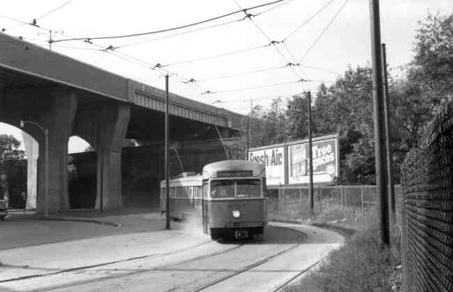 Trolley # 3034 winds its way towards the Forest Hills rotary in this 1960s photo. The Arborway overpass towers over the landscape.