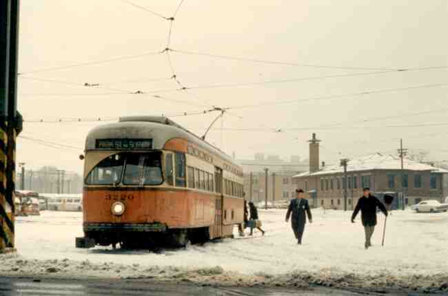 Trolley # 3220 seems to be waiting for some assistance from the MBTA Starter (in uniform) and his assistant (with the shovel) after a snow storm in this 1970 photo taken at the Arborway yard.