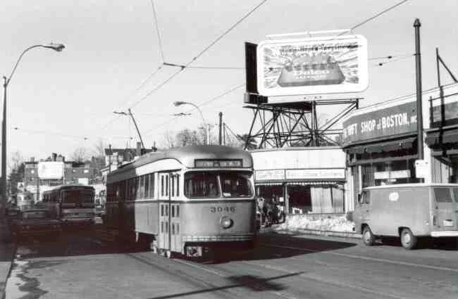 Trolley # 3046 winds its way down Centre Street in this 1969 photo. The Thrift Shop of Boston along with Centre Seafood can be seen to the right. The Donnelly advertising sign is displaying a Delco car battery ad.