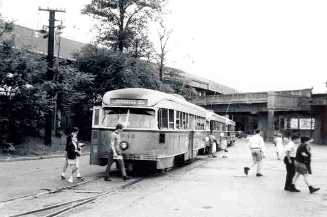 Passengers are shown making their way across the tracks in front of trolley # 3043 on its return trip from Park Street in this 1969 photo taken at the Arborway station. 