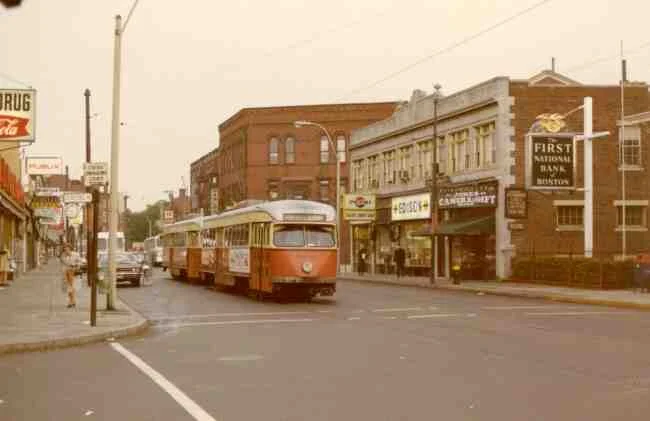 Trolley # 3046 is heading towards Park Street in this 1970 photo on Centre Street at the corner of Seaverns Ave. Some of the thriving businesses shown are the First National Bank, Jones Camera Shop, Helen's Donut Shop, The Edison Store, Hanlon Shoes, F. W. Woolworth, Hailer's Drug Store, Karsh Jewelers, Harry's Hardware, and the Publix Market.