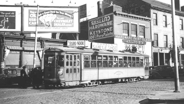Guild Row in Dudley Square. Signs advertise The Radio Nook, Hornes Sample Shoes, and Cutter's Hardware. February 1938.
