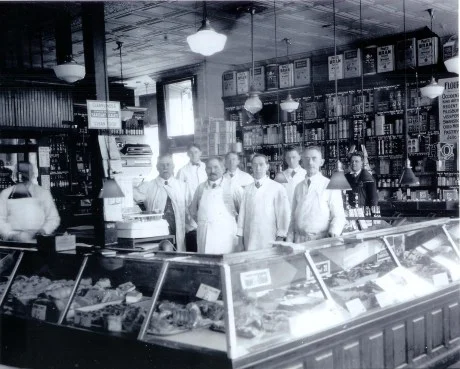 Employees of Patterson’s Market on South St. John W. Patterson stands next to the scale. George Porter is shown second from right and Josepth Patterson third from the right. Photograph provided courtesy of the Patterson family. A higher resolution version of this image is available .