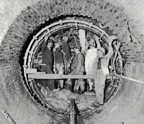 High level sewer, Centre St., Jamaica Plain. Workers are engaged in the construction of a circular tunnel using compressed air tools and a metal shield. From Metropolitan Water and Sewage Board First Annual Report. January 1, 1902. 