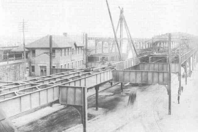Construction work nears completion on the Forest Hills Orange Line station in 1908. The Boston & Providence Railroad station is seen on the left.