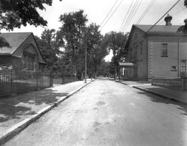 Eliot St. looking from Centre St. towards Hagar St. Eliot Hall, home of the Footlight Club is shown on the right and the parish hall of the First Church on the left.
