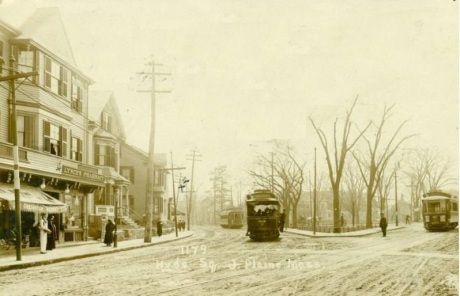   Three street cars can be seen in this view of the Hyde Square section of Jamaica Plain. The storefront on the left bears a sign, &#8220;Lynch&#8217;s Pharmacy&#8221;.&nbsp; The camera was positioned near Sherdian St. and Centre looking towards the 