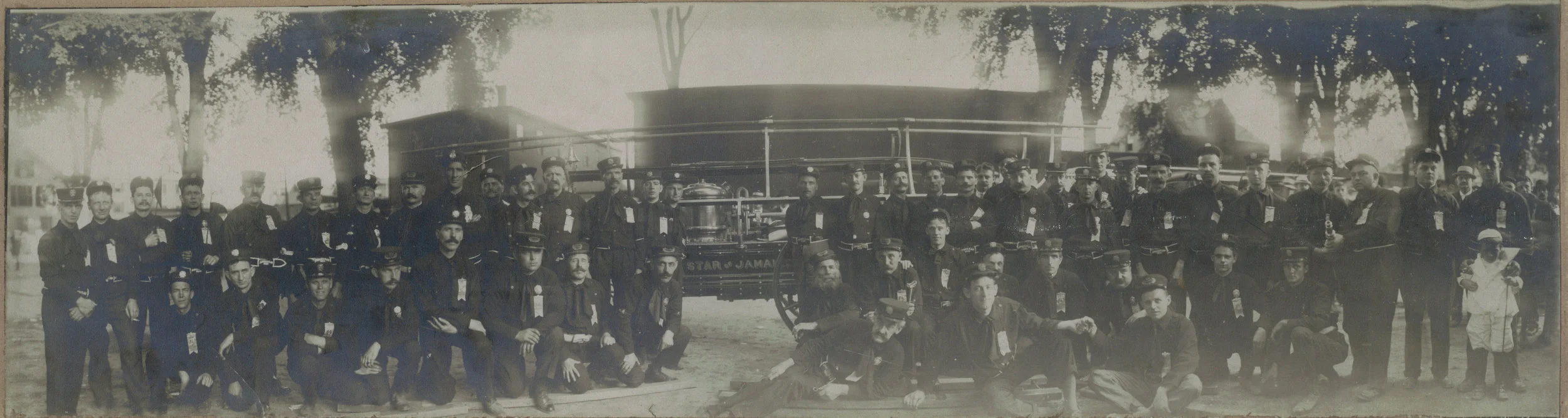 Jamaica Plain, Massachusetts firemen pose in front of their hand-tub engine, Star of Jamaica. The Star of Jamaica was originally delivered to Adrian, MI, in 1859 and was acquired by the Jamaica Plain Veterans in 1908. Although undated, this photograph may have been taken in 1908 soon after the engine was acquired. Photograph donated to the Jamaica Plain Historical Society by William Glynn. Download