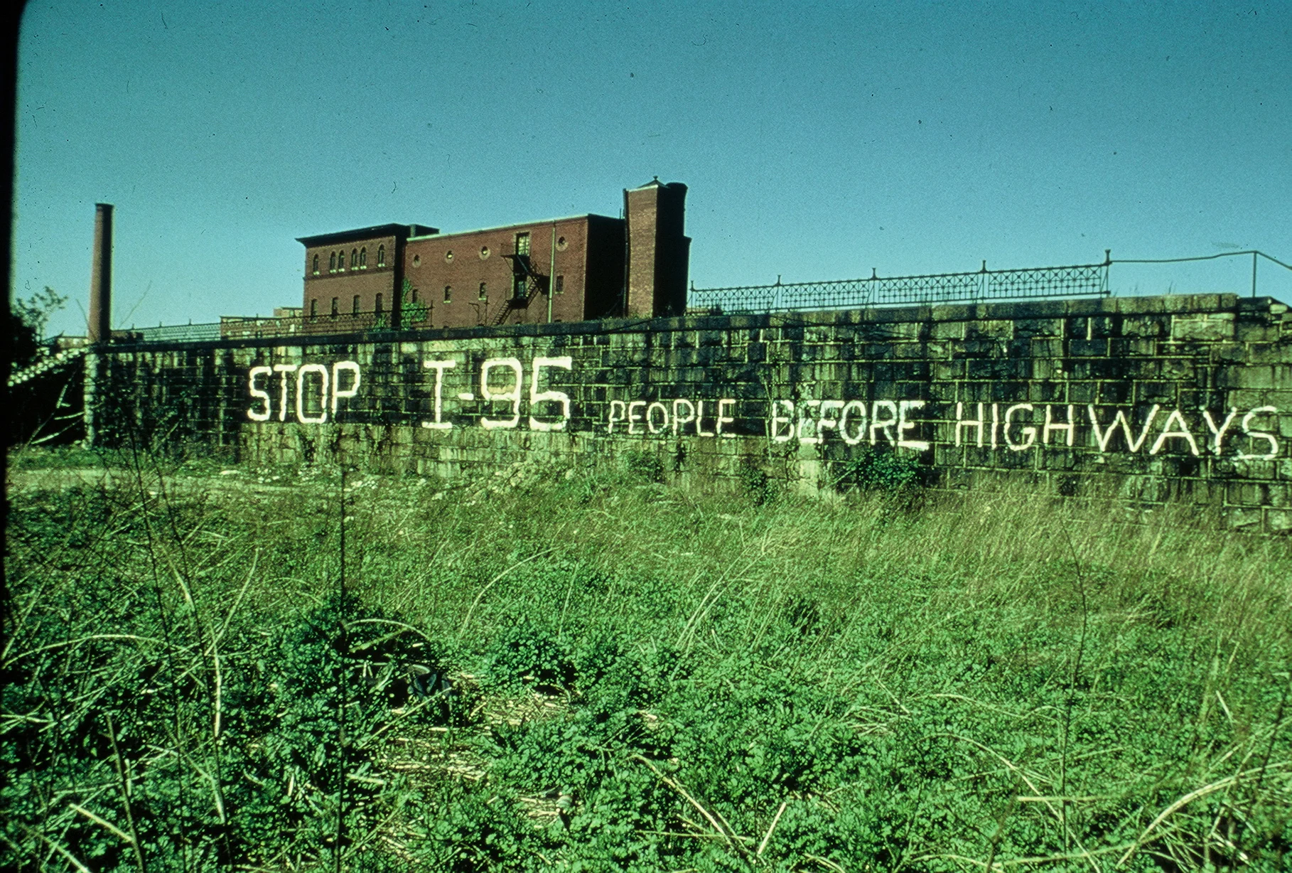 Graffiti opposing an elevated highway through Jamaica Plain and other communities painted circa 1969. Photographer unknown. Circa 1970. The graffiti was on the east wall of the embankment, facing Columbus Avenue and just north of the intersection with Tremont St. Photograph courtesy of John Bassett. Download