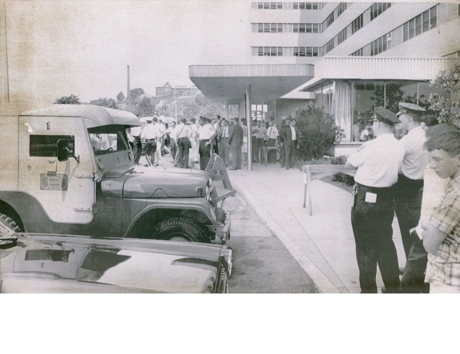 Scene on July 26, 1966 at the Veterans Administration Hospital in Jamaica Plain after three gunmen robbed an armored car, shown on left, of $60,000. Two guards were wounded in their legs. Bullets hit the truck and hospital windows.