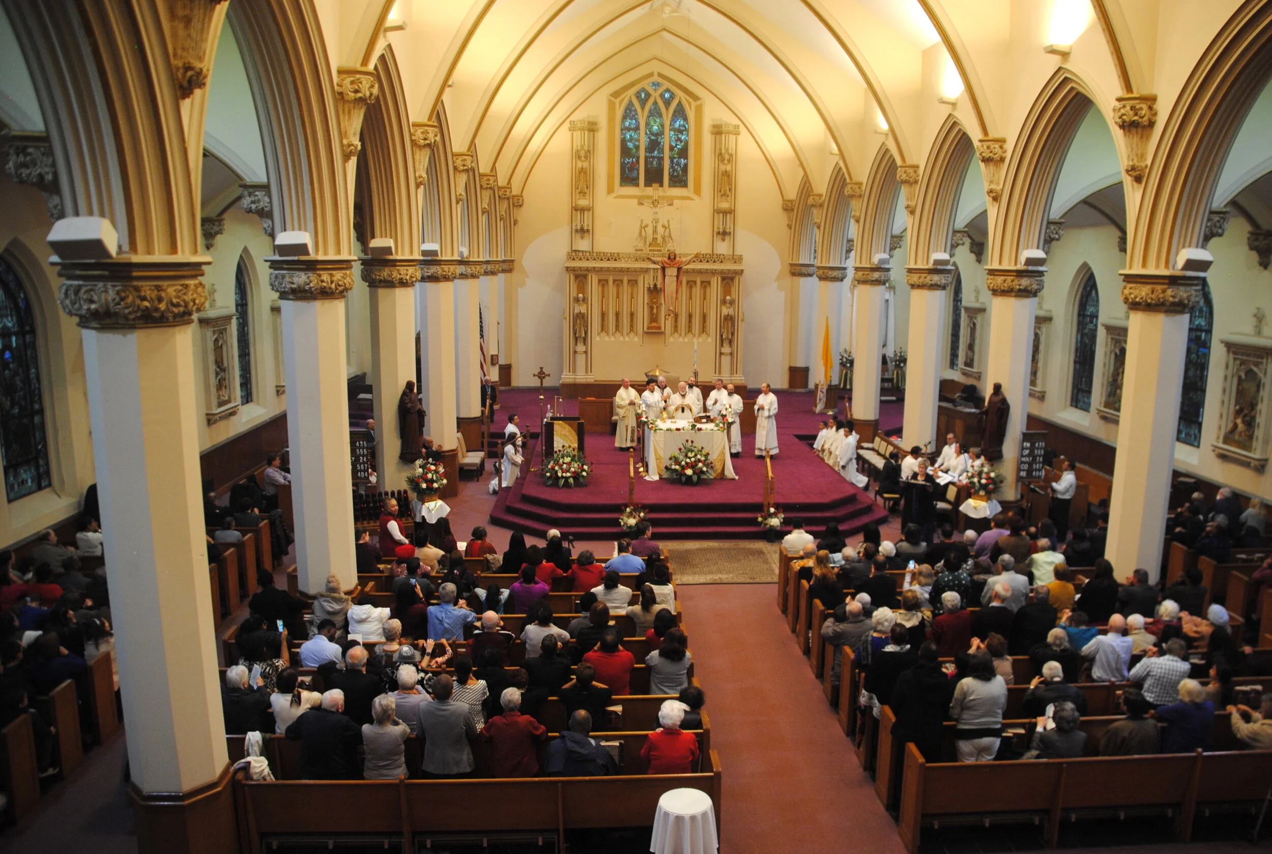  Interior of the sanctuary from the balcony showing the 1915 chancel, rederos and stained glass.  Photograph taken during the 15th anniversary mass. Nov 24, 2019. Phtoograph by Richard Heath 