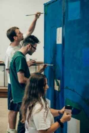 Tulane students painting the map of the Americas for the exhibit.