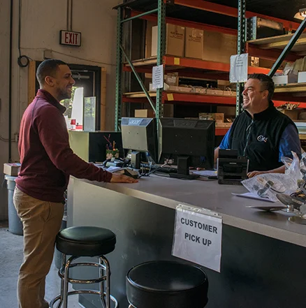 Customer being greeted by friendly employee at the parts counter in the warehouse.