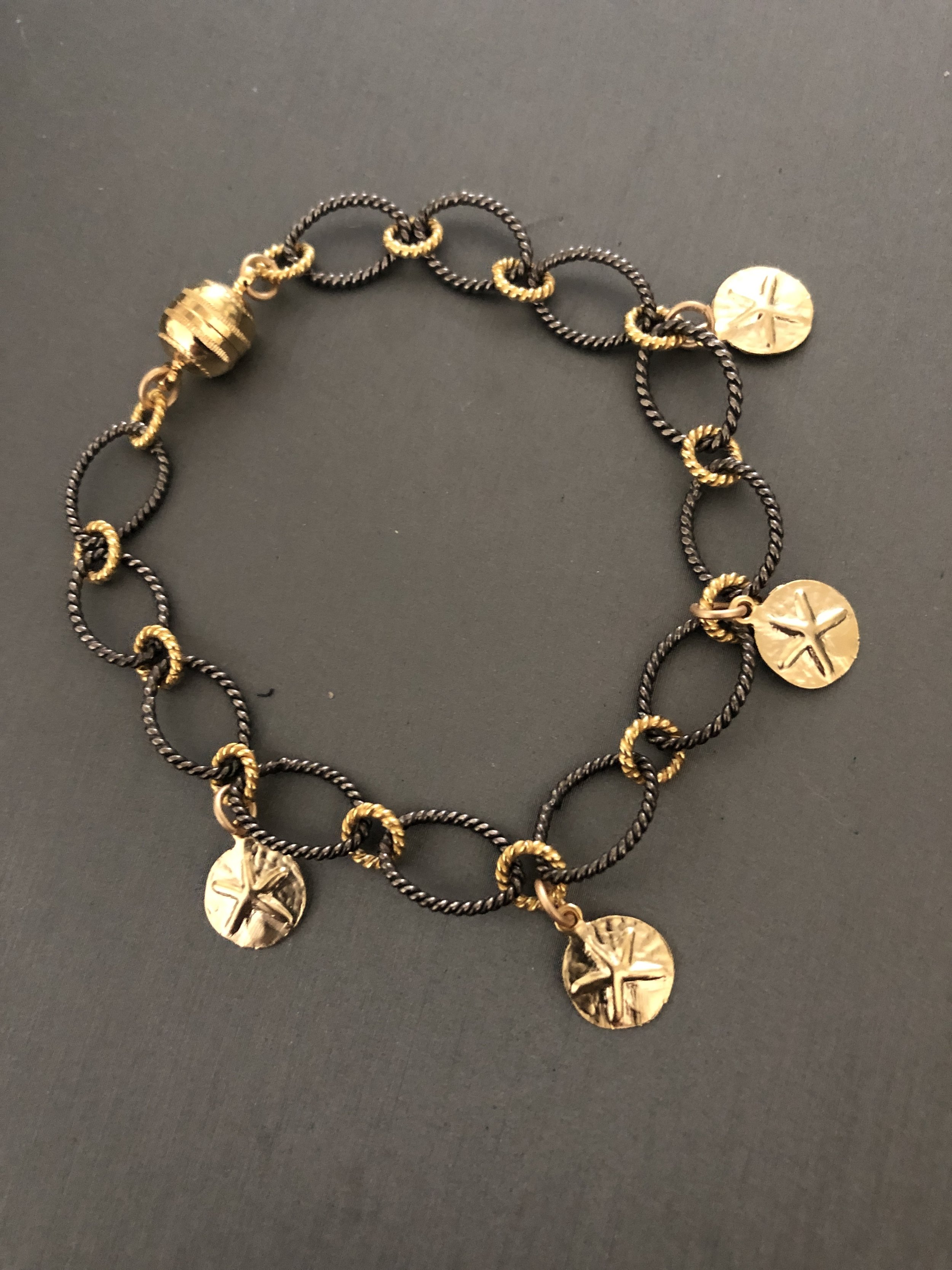 Gold sand dollars on black/gold link bracelet